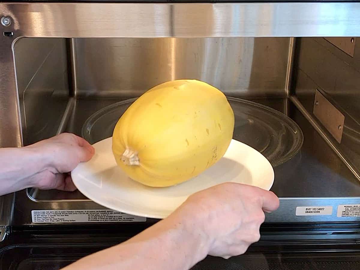 Placing spaghetti squash in the microwave. 