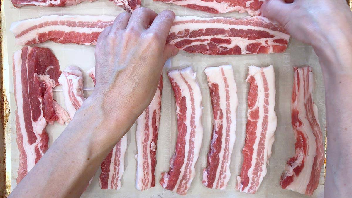 Arranging pork belly slices in the pan.