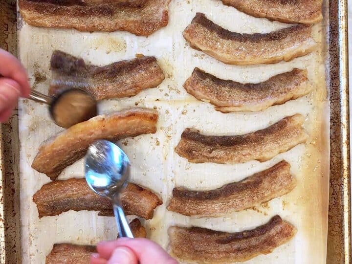 Flipping pork belly strips in the pan.