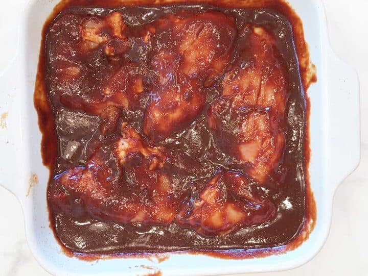 Chicken thighs are covered in BBQ sauce.