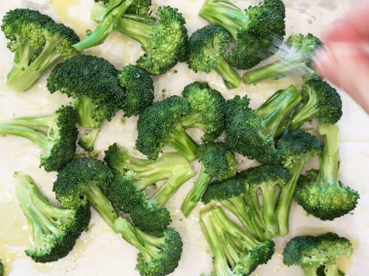 Seasoning the broccoli with salt.