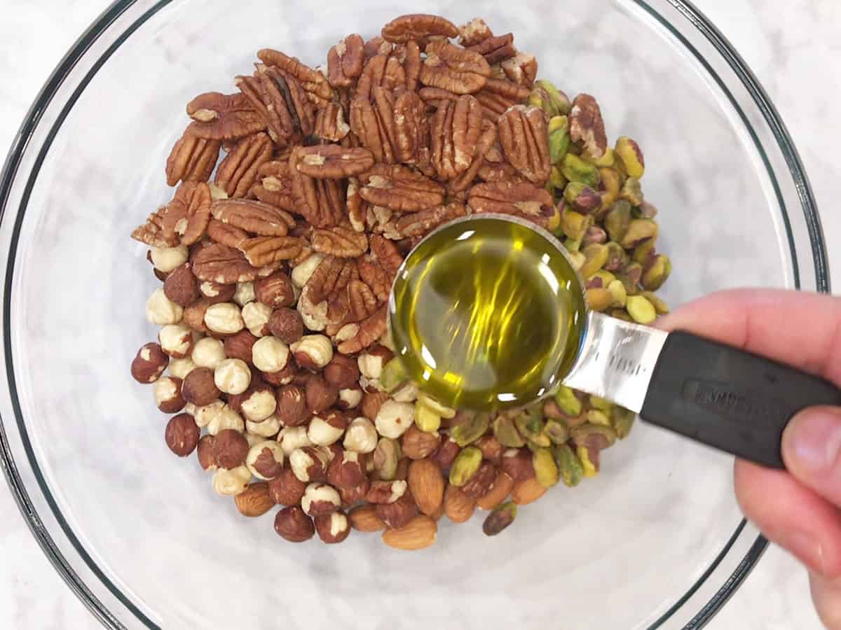 Adding olive oil to the nuts.