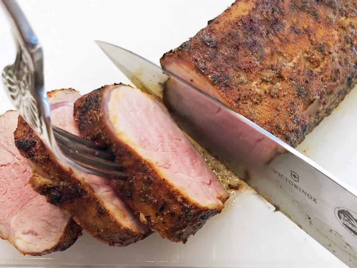 A sliced roasted pork tenderloin. The meat is slightly pink. 