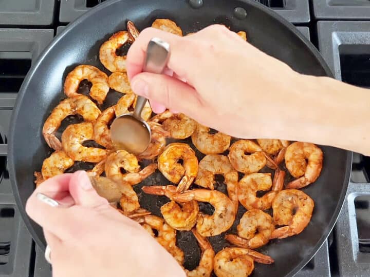 Flipping the shrimp in the pan.