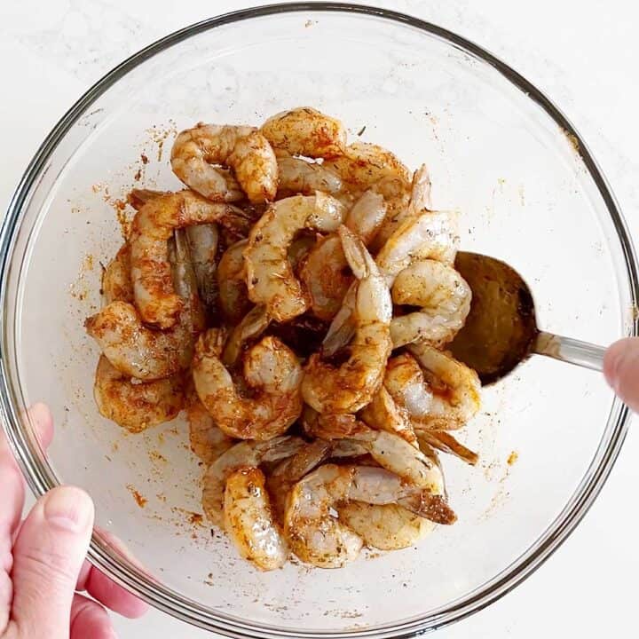 Mixing the shrimp with oil and spices.