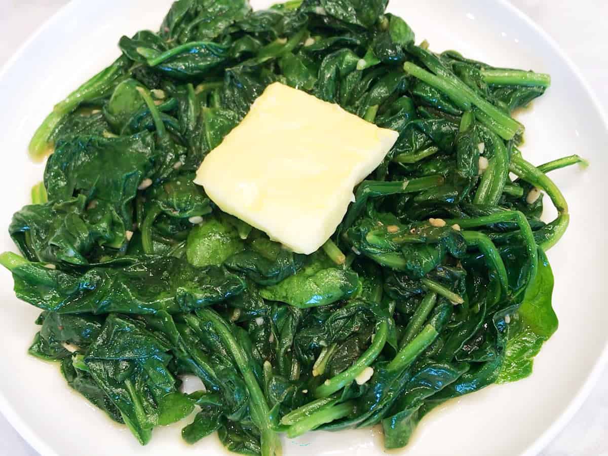 Topping sauteed spinach with butter.