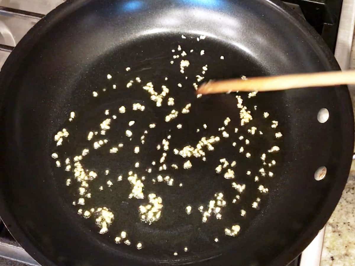 Cooking garlic in olive oil in a skillet.