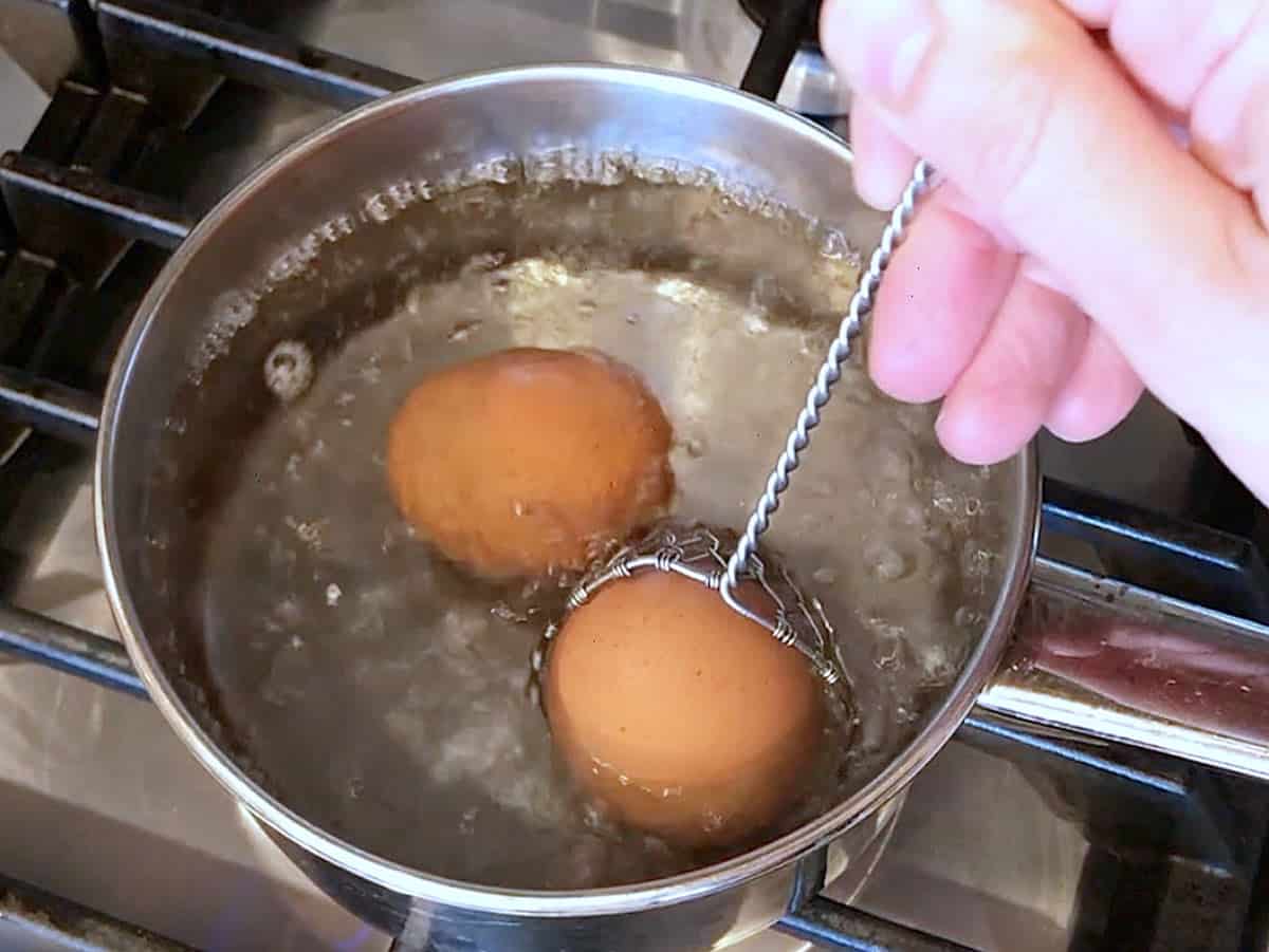 Lowering the eggs into boiling water. 