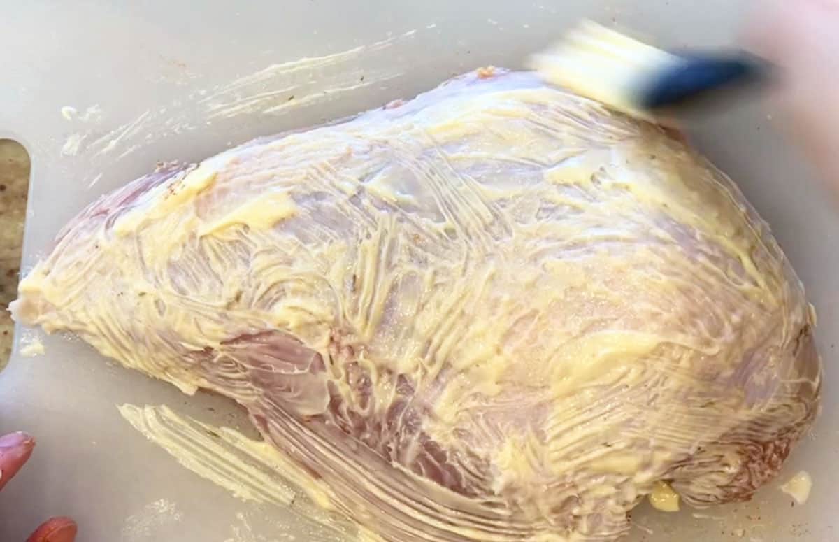 Brushing a turkey breast with butter. 