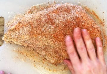 Rubbing turkey breast with spices.