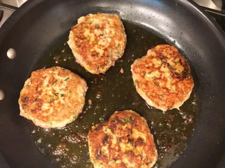 Cooking turkey burgers in a skillet.