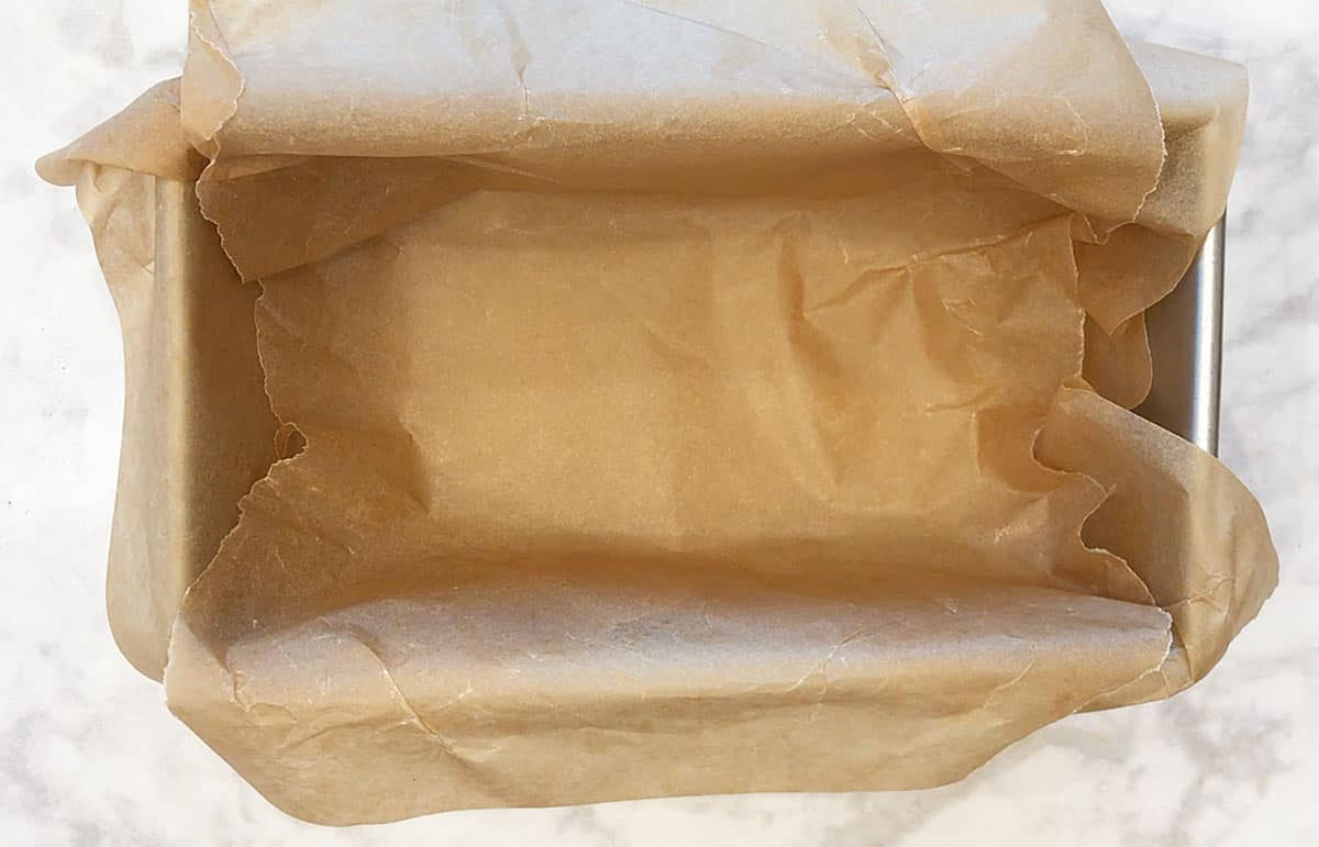 Loaf pan lined with parchment paper.