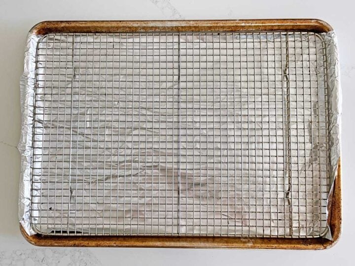 A rack fitted inside a rimmed baking sheet.
