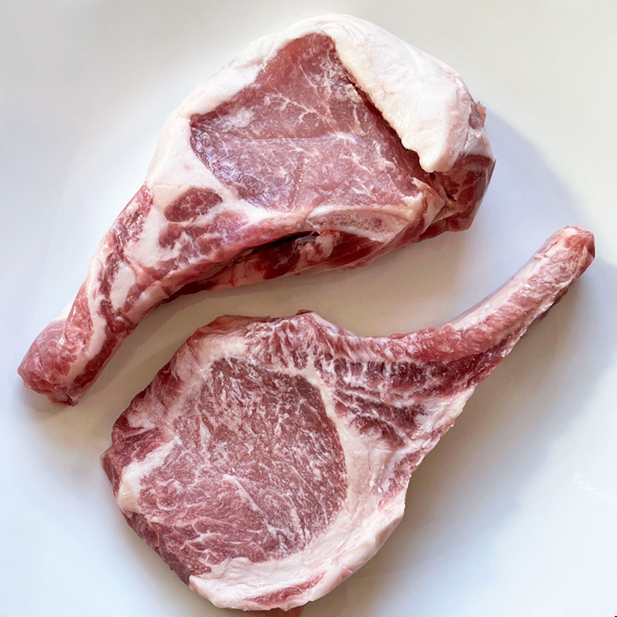Raw bone-in pork chops. 
