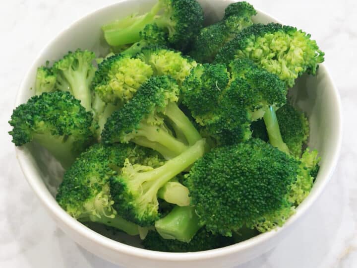 Microwaved broccoli florets in a bowl.