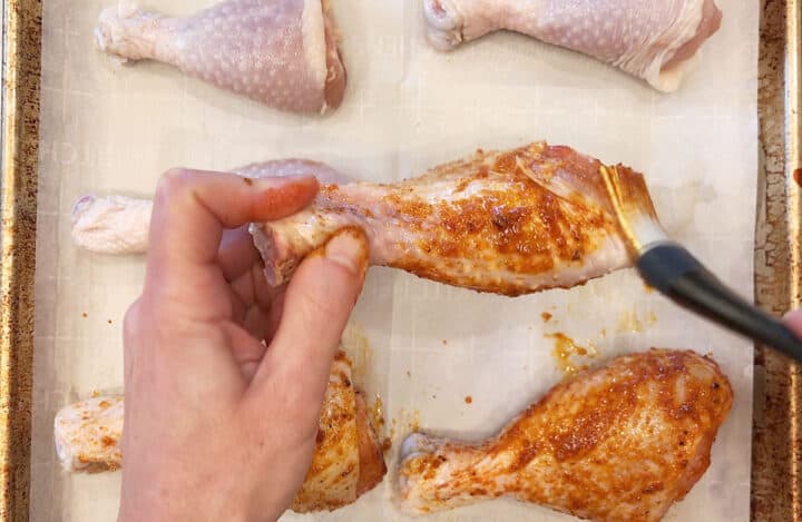 Coating chicken drumsticks with seasoning mix.