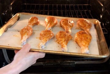 Placing the drumsticks in the oven.