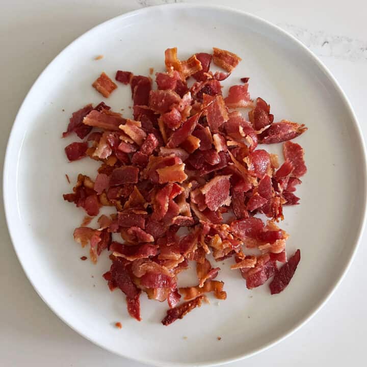 Chopped bacon on a white plate.