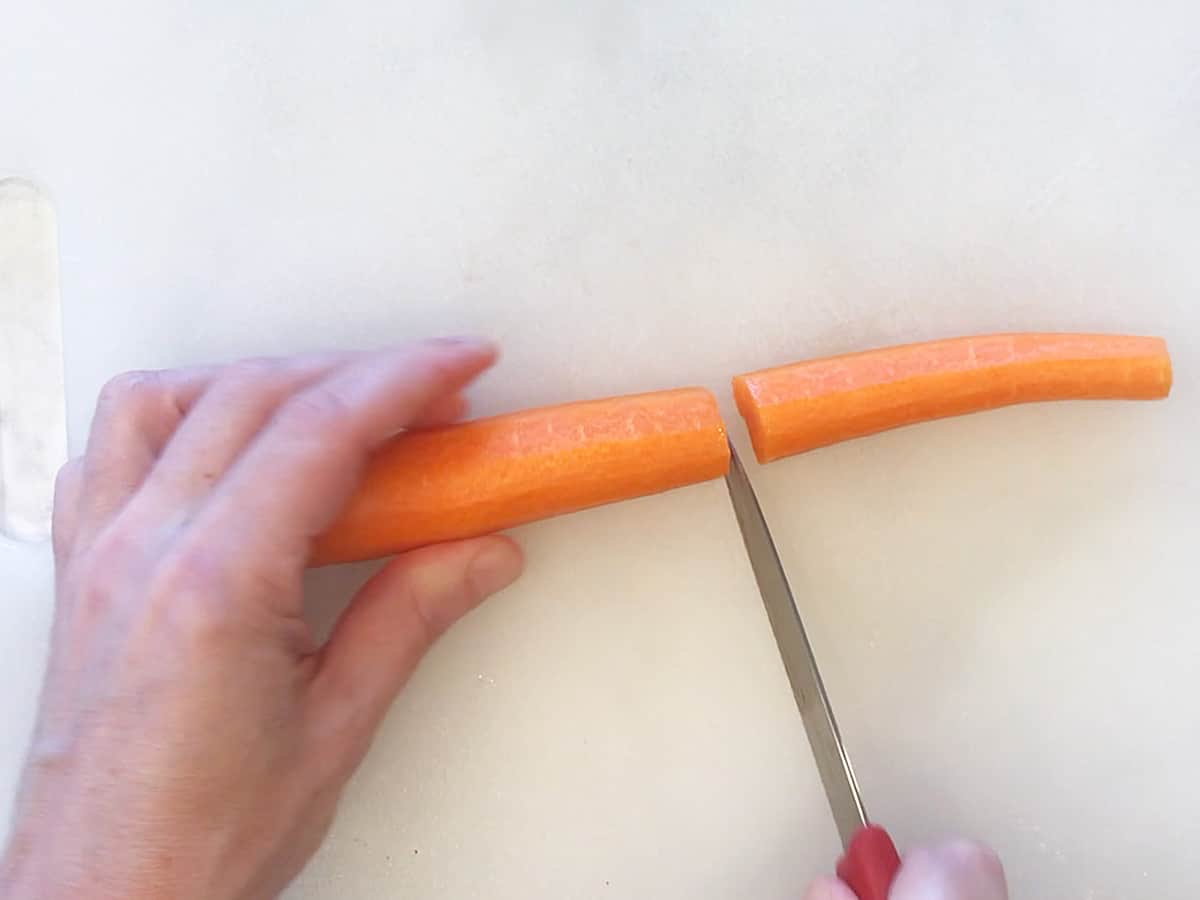 Cutting a carrot in half.