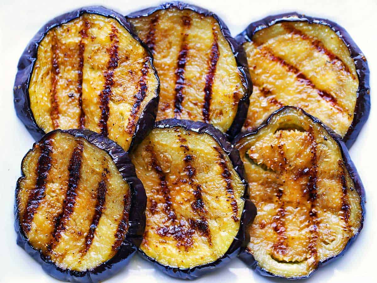 Slices of grilled eggplant arranged on a plate. 