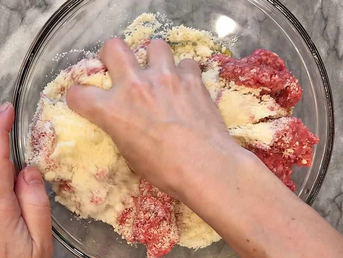 Mixing the meatloaf ingredients in a bowl.