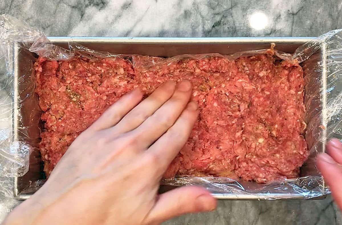 Shaping the meatloaf in a loaf pan.