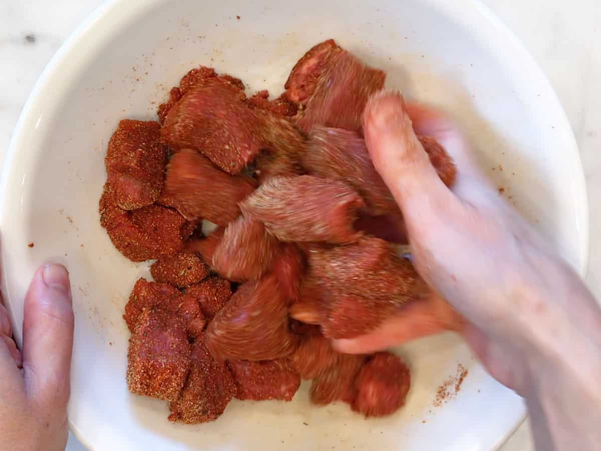 Mixing the spices into the steak.