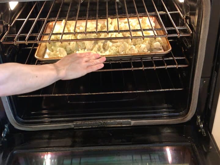 Placing the cauliflower in the oven.