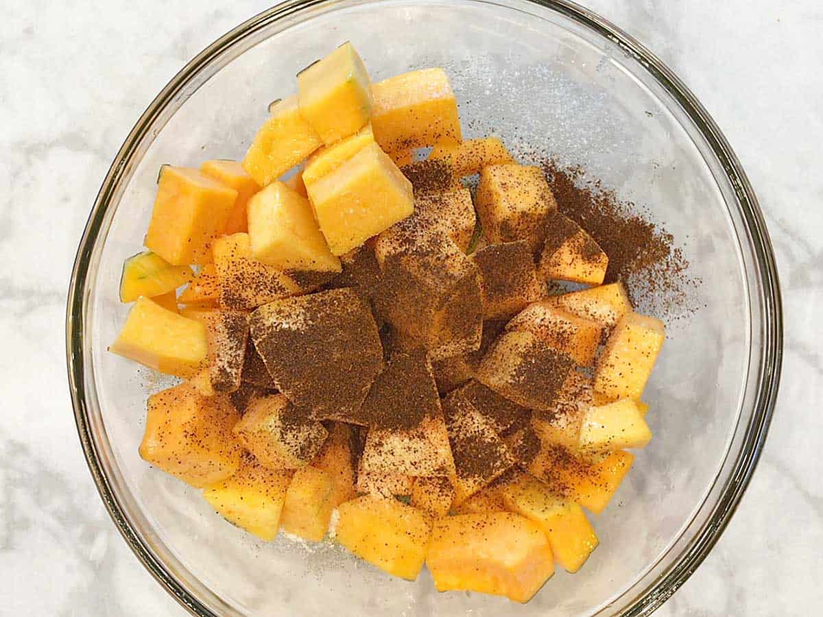 Add spices to butternut squash cubes in the bowl.