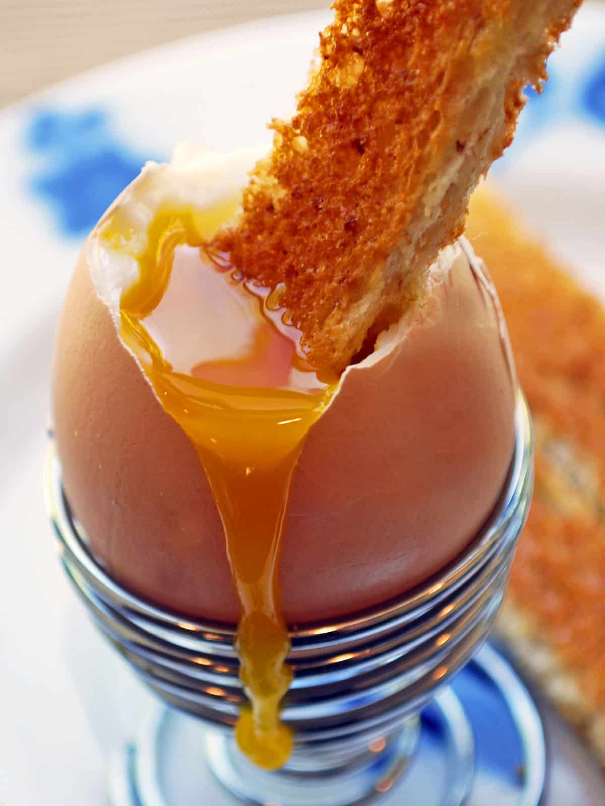 Toast dipped into the thick yolk of a soft-boiled egg. 