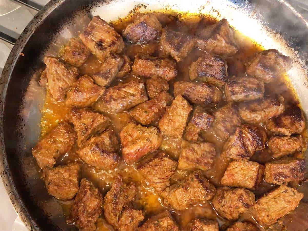 The steak cubes are ready in the skillet.