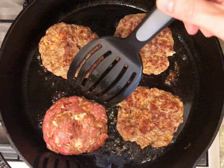 Cooking the burgers in a cast-iron skillet.