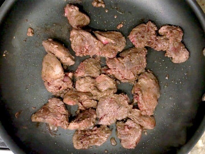 Cooking chicken livers in a skillet.