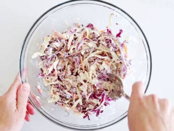 Mixing the cabbage and dressing.