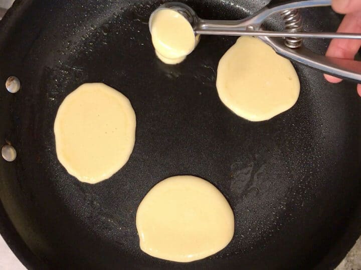 Pouring the pancakes into the skillet.