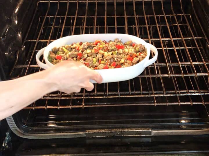 Placing the sausage stuffing in the oven.