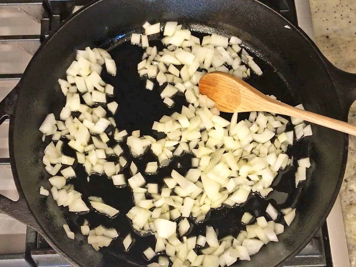 Cooking chopped onions in a skillet.