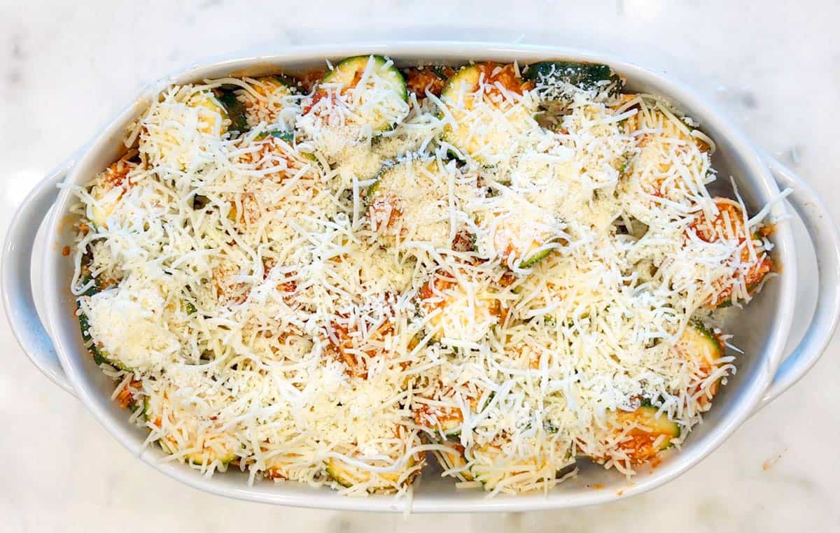 Topping the casserole with cheese.