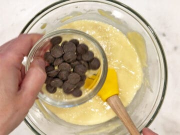 Adding chocolate chips to the batter.