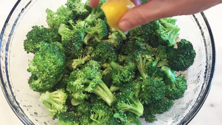 Squeezing lemon juice on microwave broccoli.