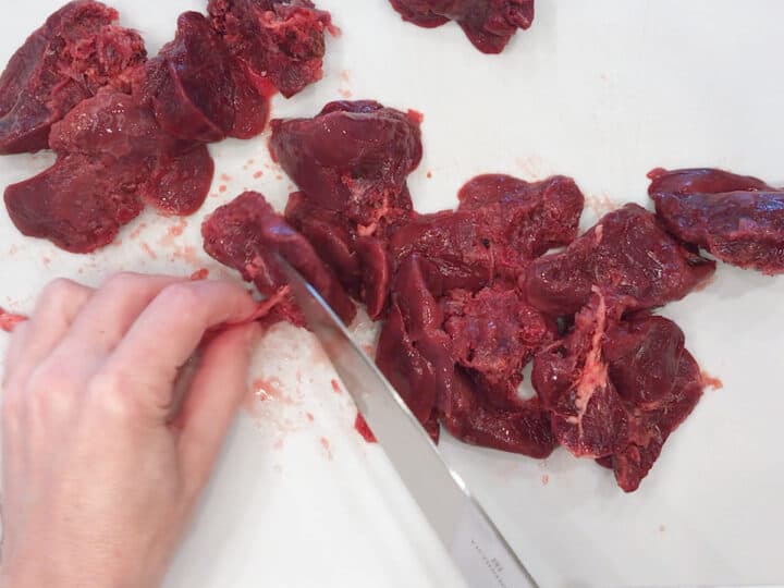Cleaning the connective tissue of chicken livers.