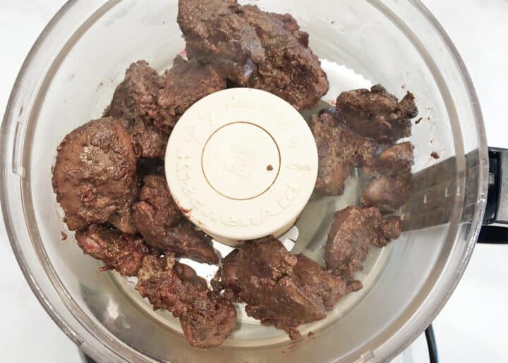Placing the cooked livers in the food processor.