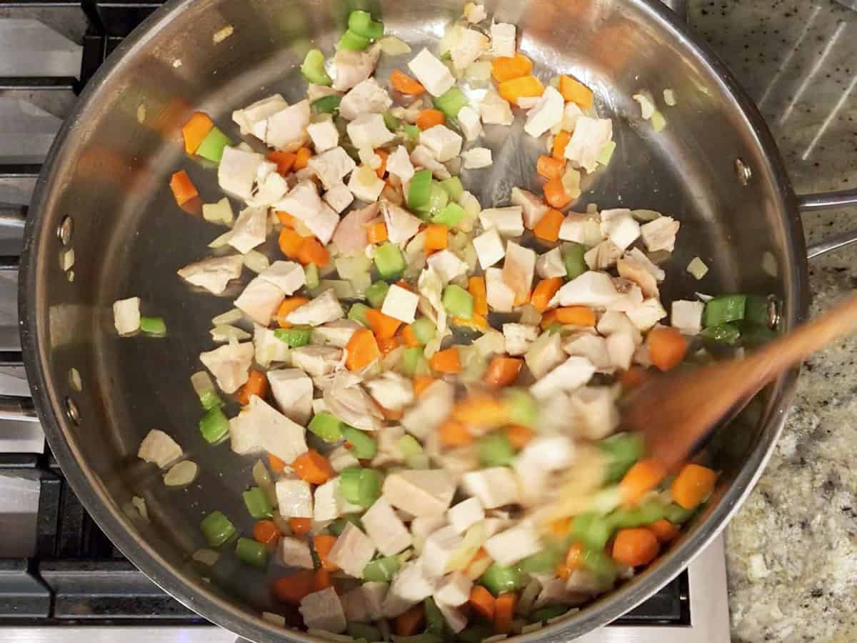 Sauteing the vegetables and turkey pieces.