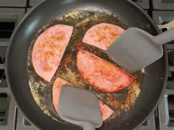 Flipping ham steak in the skillet.