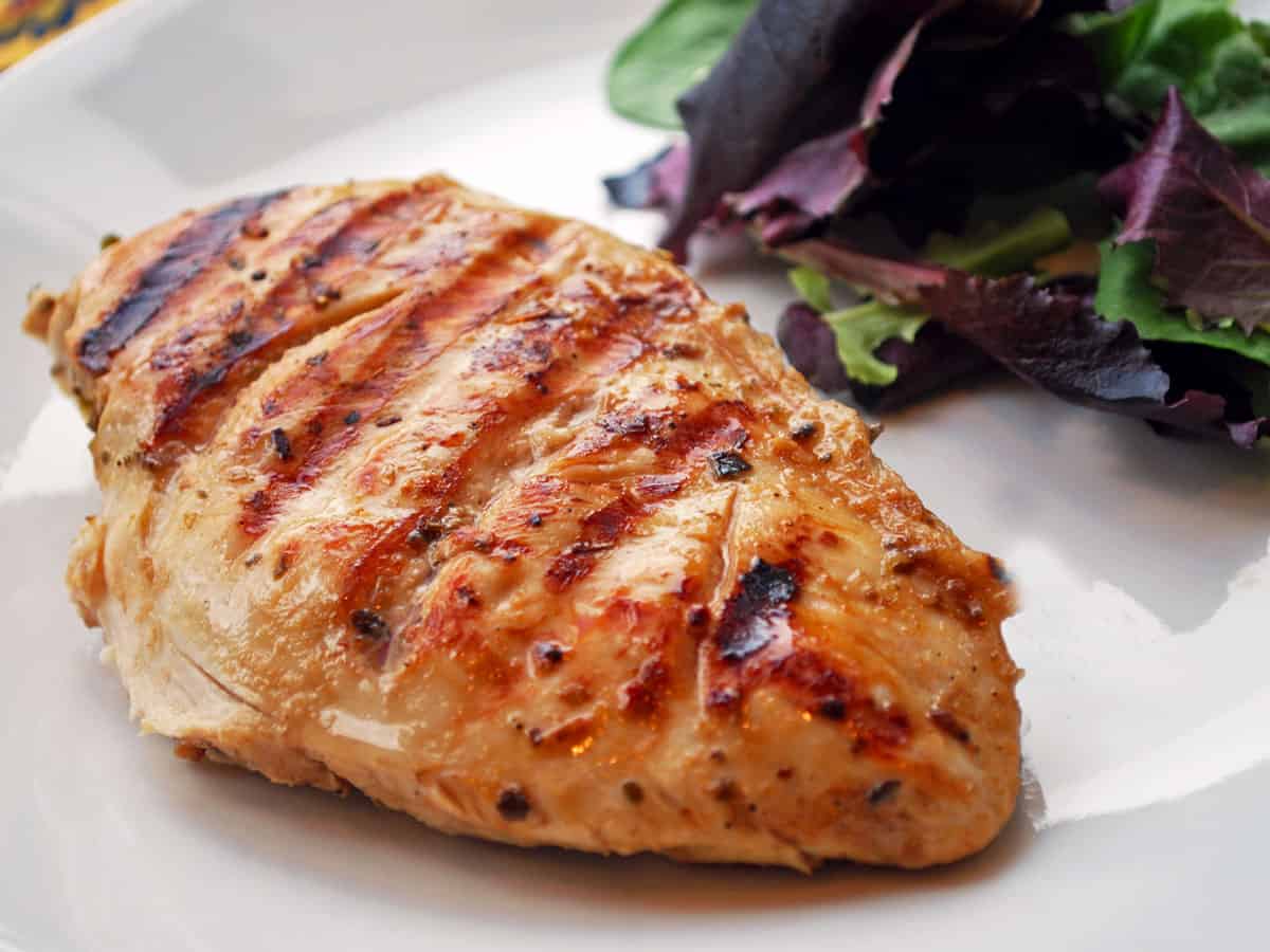 Grilled chicken breast served with a salad.
