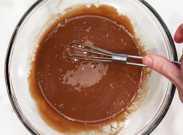 Mixing eggs into the melted chocolate.