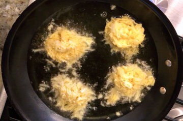 Cooking latkes in a skillet.