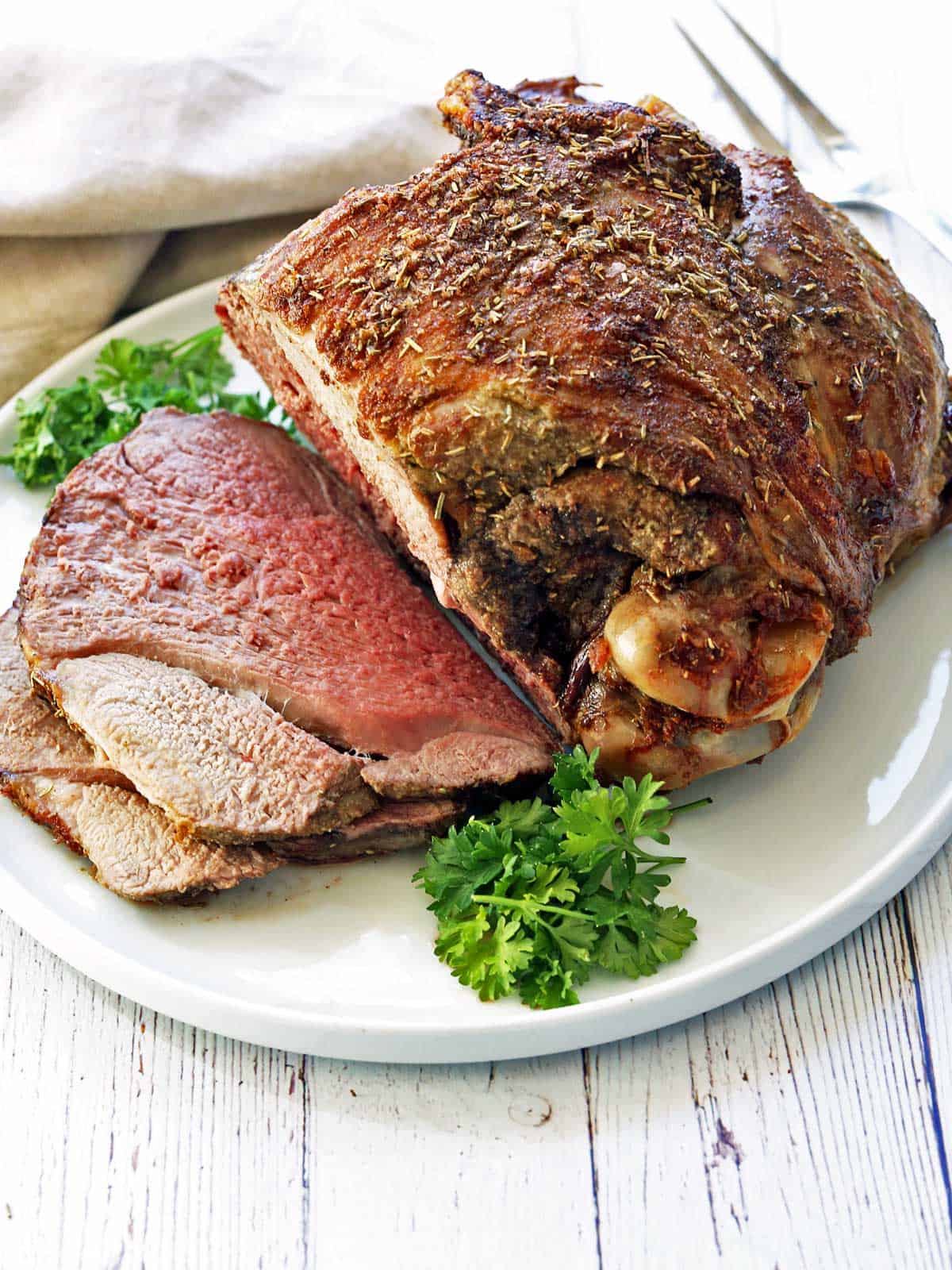 A roasted leg of lamb garnished with parsley.