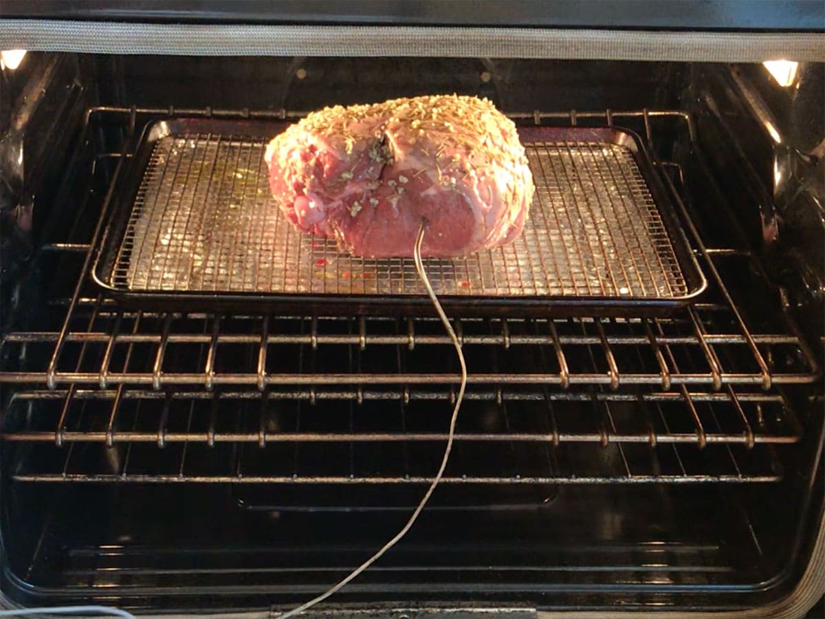 Placing the leg of lamb in the oven.