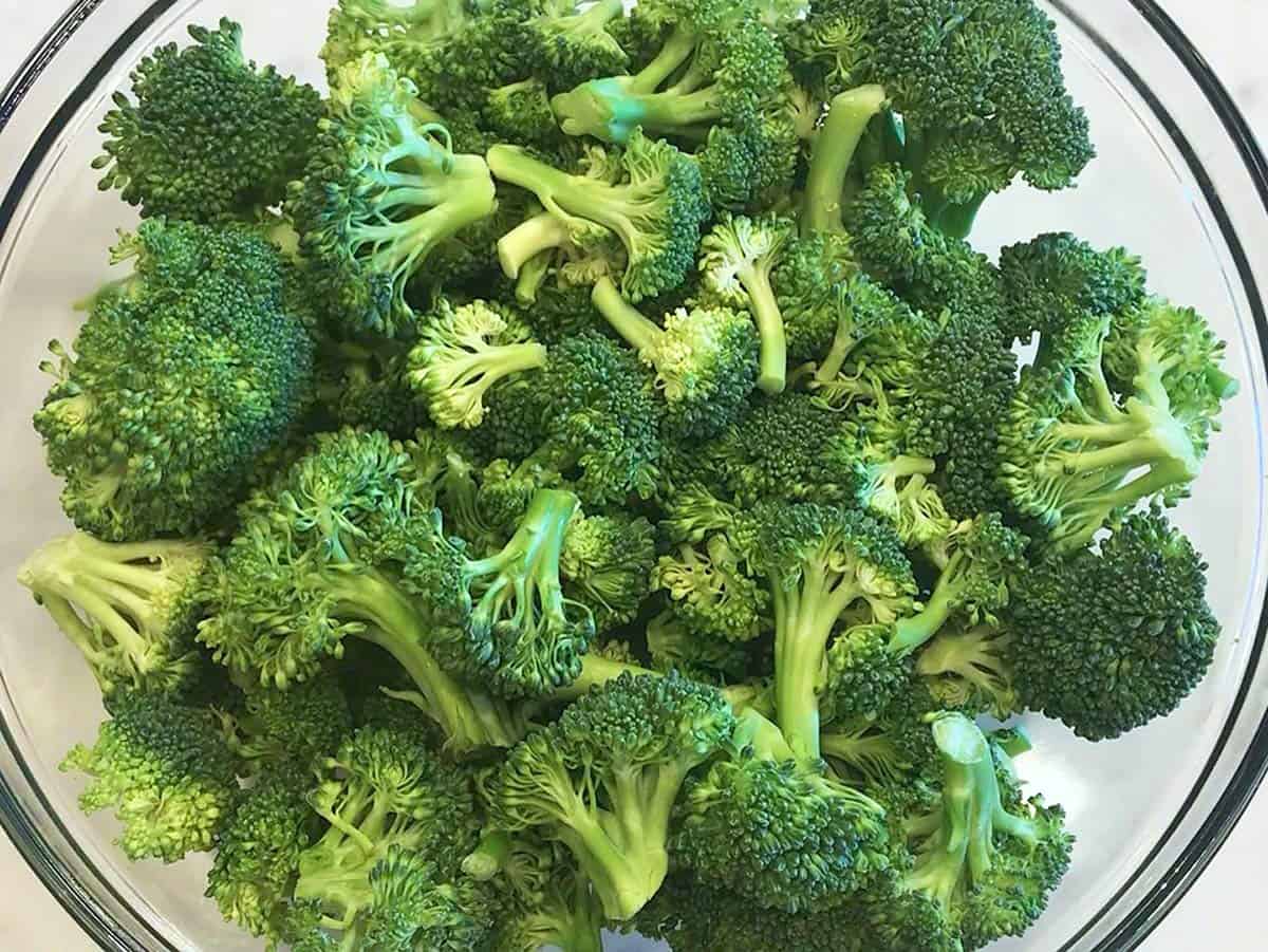 Raw broccoli florets in a bowl.